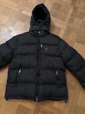 Svart pufferjacka från Polo Ralph Lauren - Skitfet stickad Ralph lauren lufferjacka💫Skick 9/10, knappt använd✅ Storlek Xs/Extra Small✅  Nypris 6500, vårt pris 2999✅ Köptes på outlet city metzingen i Tyskland 🇩🇪  Om du vill ha mer bilder hör av dig i pm🙌