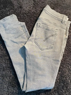 Grå jeans, dondup george. storlek 32 - Säljer ett par ljusgrå jeans från Dondup i modellen George i storlek 32. Sitter som slim i passform och har en liten defekt men inget man tänker på.