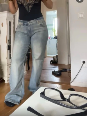 Ljusblå bootcut jeans - Säljer ett par ljusblå jeans med bootcut-modell och normal passform. Jeansen har klassisk femficksdesign, knapp- och dragkedjestängning samt är tillverkade i denim. Perfekta för dig som gillar en avslappnad och trendig look.