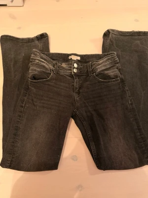  bootcut jeans Gina Tricot - Säljer ett par svart/gråa bootcut jeans från Gina Tricot Young i storlek 164. Jeansen har två knappar i midjan, klassiska fem fickor och lätt tvättad look. Materialet är jeans med stretch och passformen är normal. Perfekta jeans, älskar😍 
