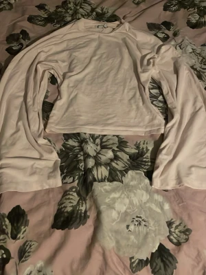 Ljusrosa långärmad topp - En enkel och stilren ljusrosa långärmad topp från lager157 i storlek xs. Modellen är rak och något croppad, vilket ger en modern vibe. Perfekt att matcha med jeans eller kjol för en clean look.