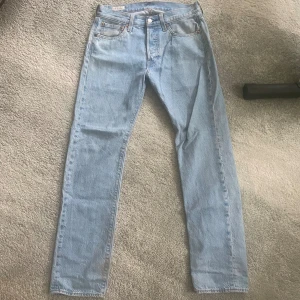 Levis 501 - Ett par snygga 501 i storlek 28/32 i ljusblå. Defekter vid benändan smuts går förmodligen bort med Vanish har ej testat. 