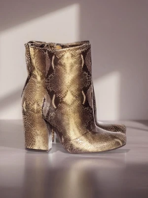Ormmönstrade boots med klack - Säljer ett par boots i ormmönstrat skinn med chunky klack från The Last Conspiracy.  Perfekta för dig som vill sticka ut med ett djurmönster och gillar statement-detaljer. Märkta som storlek 38 men är mycket mycket små storleken och passar  storlek 36.  De är oanvända då de var för små för mig som har storlek 38. Nypris 1800kr