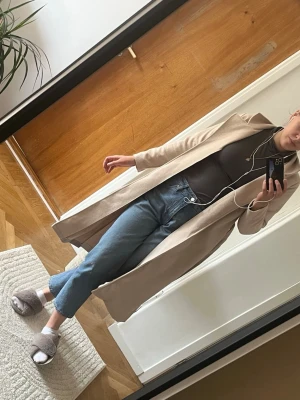 Beige lång kappa med bälte - Med stor sorg säljer jag min fina trenchcoat då den e för liten för mig 🥹 beige kappa i lång modell med bälte i midjan. Storlek S 
