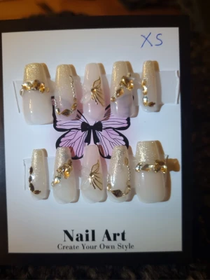 Nude lösnaglar med guldglitter Strl XS - 10st långa lösnaglar tillverkad av matt akryl, som är stark och hållbar. Nagelfil och applikator inkluderas.                                          Mått( båda vänster och höger är samma )  Tumme =       1,8 cm bredd längd 2,5 cm Pekfinger =   1,5 cm bredd längd 2 cm Långfinger = 1,5 cm bredd längd 2cm Ringfinger = 1,5 cm bredd längd 2 cm Lillfinger =    1,2 cm bredd  längd  2 cm      OBS! Storleken är baserad på manuell mätning och kan variera med 1–2 cm. 