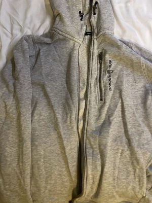 Sail racing hoodie  - Säljer en grå hoodie från sail racing. Passar på både killar och tjejer 
