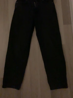 Svarta jeans från Pull&Bear - Svarta jeans från Pull&Bear med klassisk femficksdesign och rak passform. Jeansen har midja med knapp och dragkedja, tillverkade i ett slitstarkt bomullsmaterial. Perfekta för dig som gillar en enkel och stilren look.