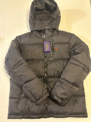 Svart pufferjacka från Polo Ralph Lauren - Helt ny svart pufferjacka från Polo Ralph Lauren i storlek M. Skriv vid intresse! 