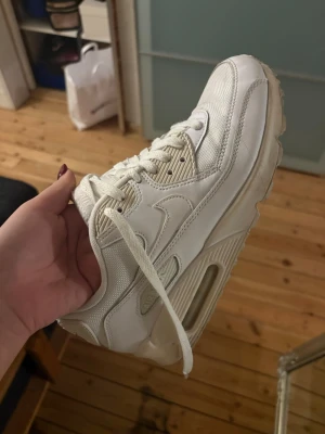 Nike Air Max 90 vita sneakers - Säljer ett par fräscha Nike Air Max 90 sneakers i helvitt. De är i storlek 40 men de är små i storleken. Jag har storlek 39 å de funkar bra för mig🥰