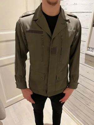 Olivgrön militärjacka - Säljer en riktigt snygg olivgrön militärjacka pga för liten för mig. Lite mindre fläckar som man ser på bilderna men inget som stör användningen. Skriv om ni har frågor! Pris kan diskuteras. 