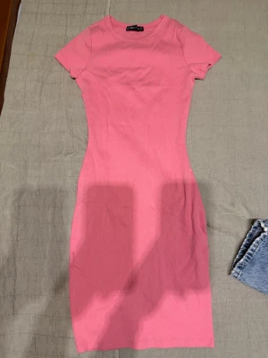 Rosa kortklänning från newyorker - Säljer en enkel och snygg rosa kortklänning från Ginatricot. Materialet är mjuk bomull med lite stretch som gör den bekväm att bära.  