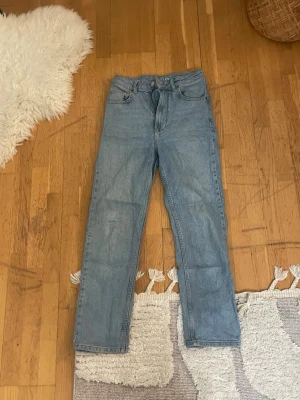 Never Denim ljusblå jeans Tower 29/32 - Säljer ett par ljusblå jeans från Never Denim, modell Tower med rak passform. Klassisk femficksdesign och snygga kontrastsömmar. Jeansen är tillverkade i slitstark bomullsdenim och har normal midja. Perfekt för dig som gillar enkel och clean stil.