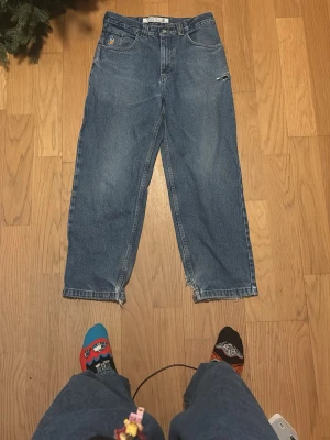 Dunder feta Baggy polar 93 denims - Säljer ett par blå polar 93 denims jeans med baggy passform rätt så slitna så jag säljer dem billigt! Jeansen har klassisk femficksdesign, broderad patch på fickan och en gul etikett bak i midjan. Materialet är robust denim i bomull. 
