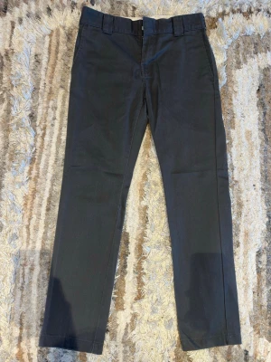 Gråa slim fit chinos från Dickies 874 - Säljer ett par gråa slim fit chinos från Dickies med klassisk design och raka ben. Modellen heter Dickies 874 Original fit Work pant. Byxorna har bälteshällor, fickor fram och bak samt diskret Dickies-logga ovanför bakfickan. Säljer dessa då dem inte använts på något år och blivit för små. Riktigt snygga som kostymbyxor eller vardagschinos🔥🤗 nypris på dessa ligger på 799kr men jag säljer för endast 299!! bara att skriva vid fler frågor eller om fler bilder önskas.