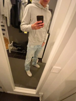 Replay Anbass ljusblå jeans slim fit - Säljer ett par Replay Anbass jeans i ljusblå tvätt med klassisk femficksdesign och röda Replay-detaljer i midjan. Jeansen har slim passform, normal midja och är tillverkade i mjukt stretchigt denim för skön komfort. Perfekt för dig som gillar stilrena och moderna jeans.