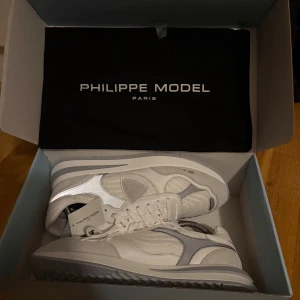 Philippe Model Vinterskor  - Snygga vita sneakers från Philippe Model med grå och silverdetaljer. Riktigt unika Philippe models som är perfekt för vintern, påminner lite om dior b30, har reflexiva delar runt om hela skon. Storlek 44EU