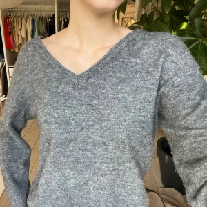 Grå stickad v-ringad tröja  - Mysig grå stickad tröja från Minus med v-ringad hals och cropped fit. Säljer då den tyvärr inte kommer till användning längre 😊
