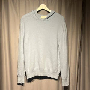 Ljus blå kashmir hoodie sayless - Mjuk och lyxig ljusgrå hoodie från Sayless i 100% kashmir. Tröjan har huva, långärmad design och ribbade muddar vid ärmslut och nederkant. Nypris 900kr
