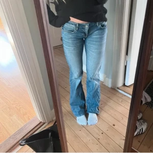 Blå bootcut jeans från LTB Roxy - Snygga blå jeans från LTB, modell Roxy, med klassisk bootcut passform och låg midja. Jeansen har fem fickor, dragkedja och knapp framtill. Materialet är mjukt denim med lätt tvättad look och subtila slitningar för en cool vibe.