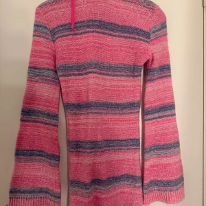 Stickad Klänning - Säljer randig rosa stickad klänning från PrettyLittleThing i storlek XS. Luftig och bekväm med öppen rygg, perfekt till stranden, utomlands eller vardagsbruk. I fint skick!