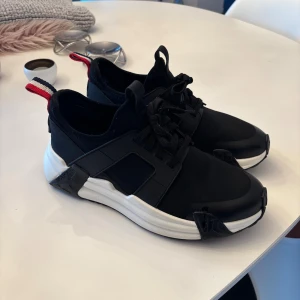Svarta sneakers från Moncler - Säljer nu mina snygga svarta skor från Moncler. Kvitto finns men tyvärr inte boxarna för dom slängde jag. Hör av er vid minsta fråga. Ny pris på dessa är 6500 ungefär och jag släpper mina för ca 2399. Priset är inte hugget i sten