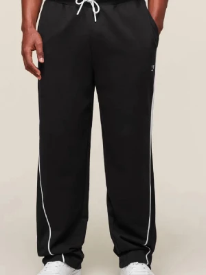 Svarta mjukisbyxor gymshark  - Svarta mjukisbyxor från Gymshark med vita snören i midjan och vita ränder längs sidorna. Byxorna har en loose passform och är tillverkade i  polyester . Perfekta för chill eller träning, med fickor på sidorna och elastisk midja.