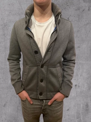 Grå kofta från Abercrombie & Fitch - Abercombie & Fitch cardigan Archive  Storlek S 9/10 skick-inga defekter Modellen är 184 cm Pris går att diskutera 🤝 Hör av er vid frågor :)