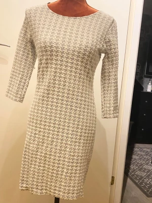 Vit och svart mönstrad klänning Sisters Point S - Snygg klänning med trekvartsärm och dragkedja baktill.  45% bomull, 41% polyester, 4% elastan Längd: 85 cm Bystvidd: 45 cm  Inga bilder när den sitter på mig! Katter finns i hemmet!
