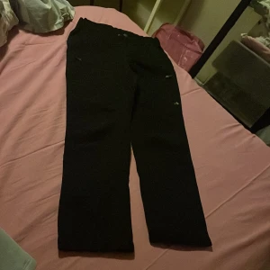 Svarta out door byxor  från Funk - Svarta lekbyxor från Funk  i storlek 140. Byxorna har dragkedjor vid fickorna och är gjorda i ett slitstarkt syntetmaterial. Perfekta för kalla dagar och utomhusaktiviteter. Snygg och enkel design med liten logga på benet.