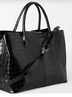 Svart axelväska i krokopräglat skinn - Snygg svart axelväska med krokopräglat mönster. Väskan har guldfärgade metalldetaljer och rymlig insida, perfekt för dig som vill ha plats för allt. Stilren och trendig design som lyfter vilken outfit som helst. Nypris 600 den säljs för 215, dock går priset att diskutera vid snabbt köp.