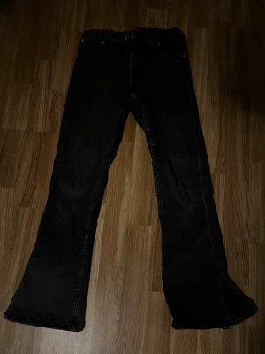 Svarta bootcut jeans från Zara - Säljer ett par svarta bootcut jeans från Zara i storlek 164. Jeansen har klassisk femficksdesign, normal passform upptill och vida ben med bootcut. Tillverkade i mjukt bomullsmaterial med stretch för extra komfort.