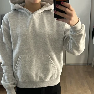 Grå hoodie från Gina Tricot  - Grå hoodie från Gina Tricot i storlek XS med ficka och muddar vid ärmslut och midja. 
