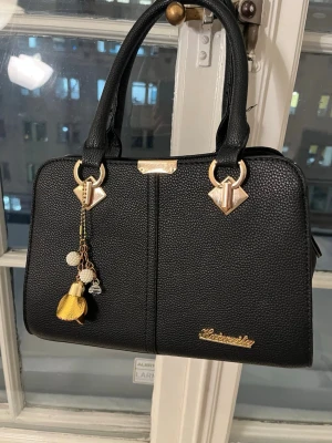 Svart handväska - Säljer denna fina läder handväskan då den ej kommer till användning. Den är helt ny, använd endast 1-2 gånger. Köptes på Amazon för ca 450kr!