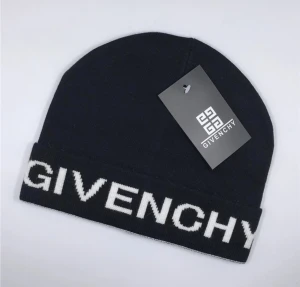 Svart mössa från Givenchy - Snygg svart mössa från Givenchy med vit logotyp i stor text på uppvikt kant. Stilren och trendig design som passar perfekt till streetwear. Mjuk stickad kvalitet som håller dig varm och ser riktigt cool ut. Äkta vara !!!