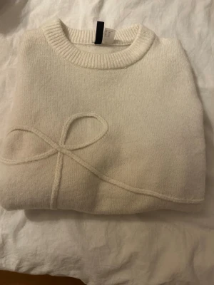 Vit stickad tröja - Jättefin och trendig stickad tröja med en rosett på. Ifrån hm i storleken xxs. Helt oanvänd och i perfekt skick. Säljer för att den är för liten för mig. Skriv om ni har frågor, vill ha fler bilder, mått eller komma med prisförslag💘💘