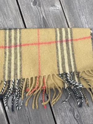 Burberry halsduk - Schön burberry halsduk i fint skick, det finns ett hål som syns på bilden men annars är den väldigt fin och det är inte heller något man lägger märke till