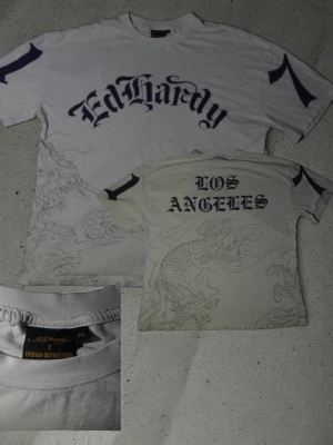 Ed Hardy x Urban Outfitters t shirt - Riktigt cool ed Hardy tröja ja köpte på urban outfitters, det är size M men passar som L. Perfekt om man vill ha den där baggy looken. 9/10 condition. ( drak printen är grå och texten & siffrorna är mörkblå vilket inte syns så bra på bild.)