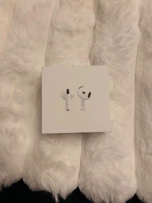 AirPods 4 - Säljer ett par helt nya Apple AirPods 4 i oöppnad originalförpackning. Trådlösa hörlurar med laddningsetui, kompatibla med USB-C-laddare. Perfekt för musik, samtal och träning. Ingen synlig skada eller slitage på förpackningen.