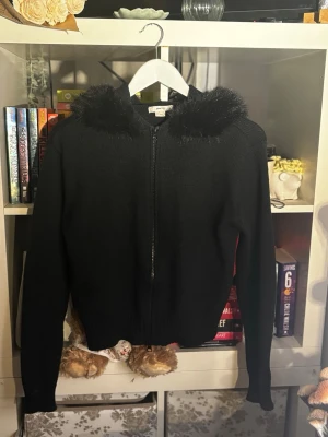 Kofta med pälsluva från gina - Säljer en svart stickad kofta från Gina Tricot i storlek M. Tröjan har en fluffig pälsluva❤️