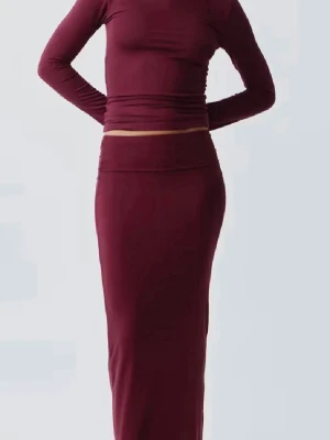 Vinröd långkjol - Vinröd tajt långkjol med nedvikbar kant. Skönt material och passar till alla tillfällen💕Använd en gång