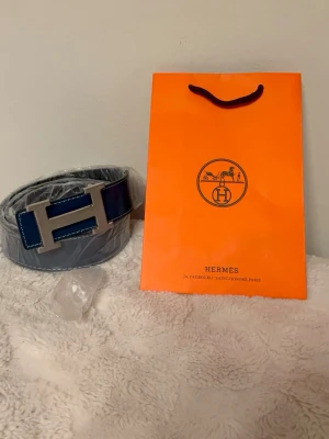 Marinblått bälte - Elegant marinblått bälte i hög kvalitet med en tidlös och stilren look. Lätt att matcha till både vardagsoutfits och mer uppklädda tillfällen. Ett snyggt accessoarval som ger en clean och exklusiv känsla.