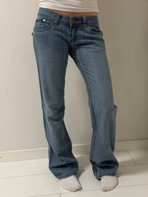 Ljusblå bootcut jeans  - Snygga ljusblå jeans med klassisk femficksmodell och bootcut passform. Jeansen har normal midja och coola detaljer på bakfickorna. Tillverkade i mjukt bomullsdenim som ger en avslappnad vibe.