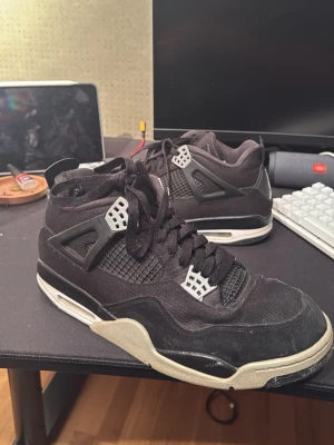 Svarta Nike Jordan 4 sneakers - Säljer ett par svarta Nike Jordan 4 sneakers med vita och grå detaljer.. KOM MED BUD!!! 100%riktiga 