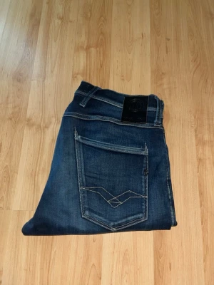 Replay Anbass jeans - Säljer dessa feta Repaly Anbass Jeans med snygga kontrastmönster. Midja 39cm, längd 103cm. Obs jeansen har defekter. Ett hål på fickan, ena på knät som samtidigt gör jeansen snygga och unika. JAG SKICKAR EJ FLER BILDER NÄR JAG BÄR JEANSEN! för bättre inblick i passformen rekommenderar jag att googla på modellnamnet. För storleksguide kolla måtten noggrant då jeansen alltid kan vara uppsydda heller krympta och jag ej tar emot returer :) 1,42