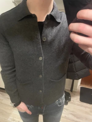 Grå stickad cardigan  - Otroligt snygg, varm och skön grå stickad cardigan. Passar perfekt till kallare väder. Modellen är 180, 75kg. 