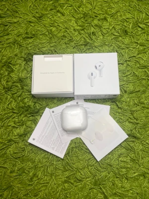Apple AirPods Pro med laddningsetui - Säljer ett par vita Apple AirPods Pro med trådlöst laddningsetui. Hörlurarna har en stilren och kompakt design i blank plast och levereras med originalförpackning och manualer. Perfekta för dig som vill ha grymt ljud och smidig anslutning till din iPhone.