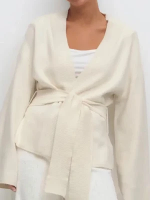 Krämvit omlottkofta med knytskärp - Snygg krämvit omlottkofta med breda ärmar och knytskärp i midjan. Koftan har en djup v-ringning och är tillverkad i ett mjukt, stickat material. Perfekt för lager-på-lager och enkel att styla till olika outfits.