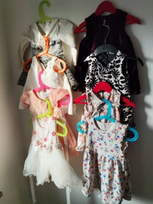 Mix av korta klänningar i olika färger 74/80 - Säljer ett paket med flera korta klänningar i olika färger och mönster. Här finns blommiga, rutiga och enfärgade klänningar i vitt, rosa, beige, svart och vinrött. Materialen varierar mellan bomull, spets och polyester. Några har spetsdetaljer, volanger och blommönster. Perfekt för dig som gillar variation!  Du är varmt välkommen att kika på mina andra annonser.