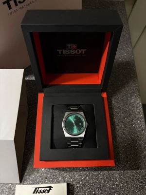 Tissot klocka med grön urtavla - Snygg Tissot klocka med grön urtavla och stilren design. Klockan har ett armband i rostfritt stål och levereras i originalask. Perfekt accessoar för dig som gillar klassisk men modern stil.