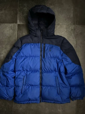 Ralph lauren pufferjacka  - Tjena, säljer nu denna riktigt snygga och populära Ralph lauren jackan, den är i bra skick men finns en reva som visas på en av bilderna, storlek XL 18-20 motsvarar S, färgen är blå/mörkblå, hör av er vid frågor och funderingar🙌🤝 